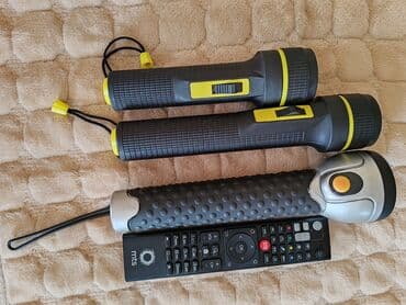 Elektro materijal: Tri ručne lampe različitih modela. Dve su crne sa žutim detaljima i — 1