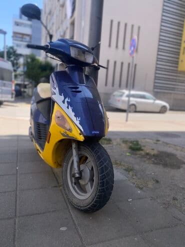 auto kamera retrovizor cena: Skuter plavo-žute boje. Ovaj skuter poseduje retrovizore, prednje — 1
